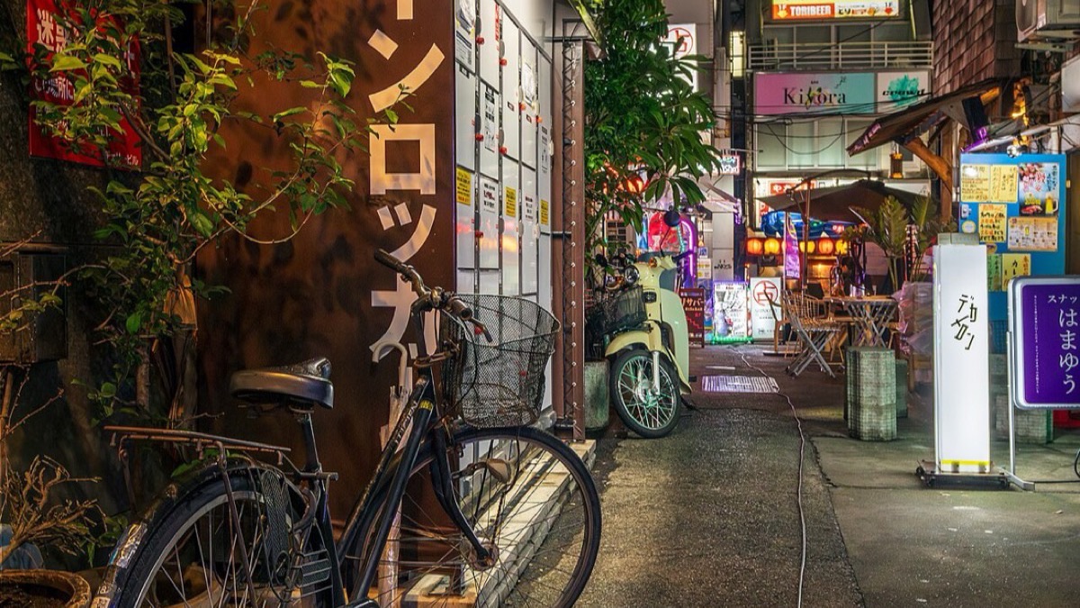 An izakaya alley in Kabuki-chō, Shinjuku at night — evoking the Tokyo streets of Sakamoto Days